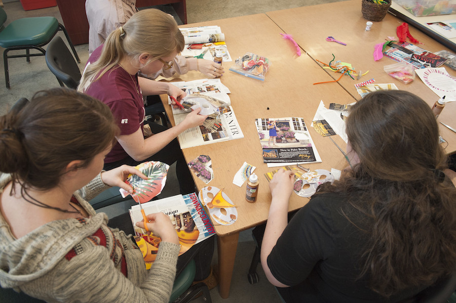 Students creating collages from magazine clippings in an art therapy class.
