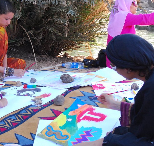 Egyptian women painting with water colours, on the banks of Heisa Island Aswan, as a part of an art therapy session.